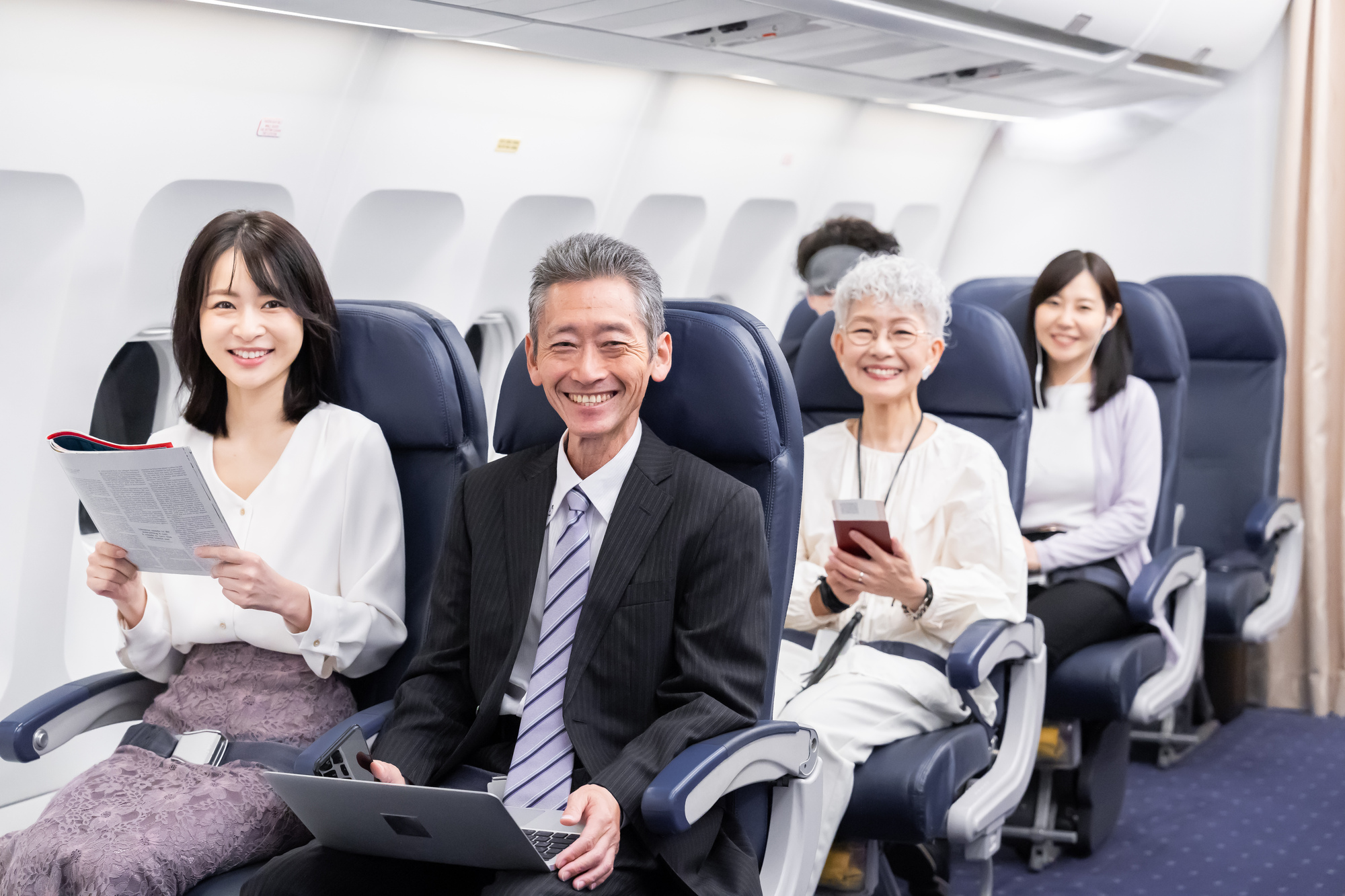 笑顔で飛行機に乗る人達のイメージ