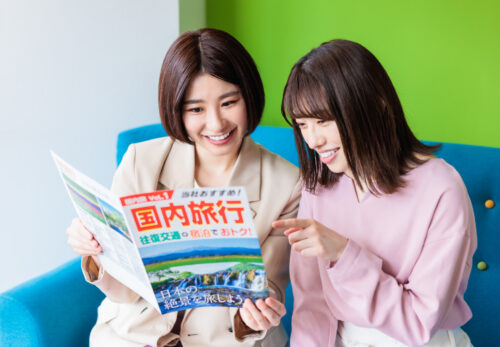 旅行雑誌を読む2人の女性