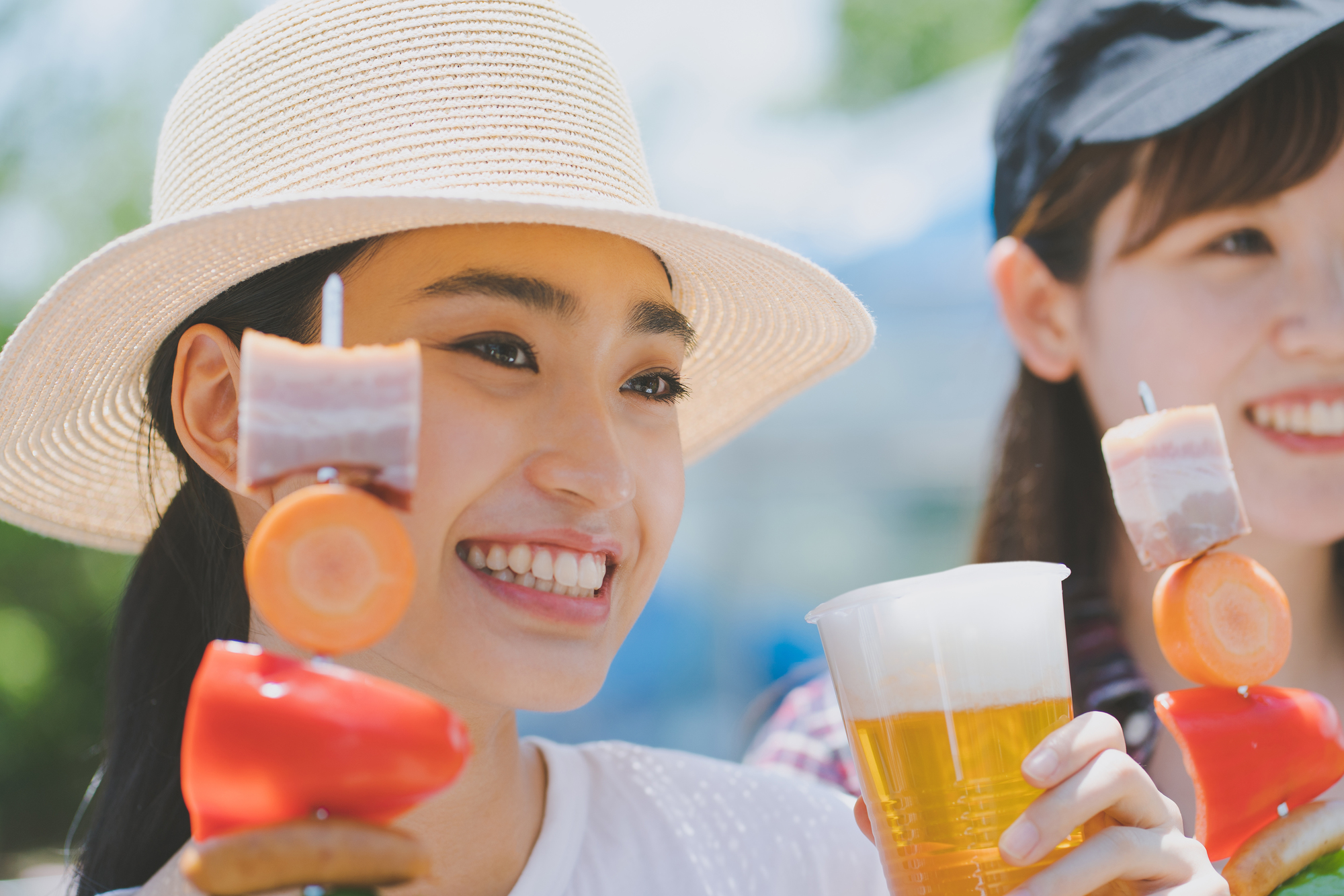 BBQ串とビールを持つ女性