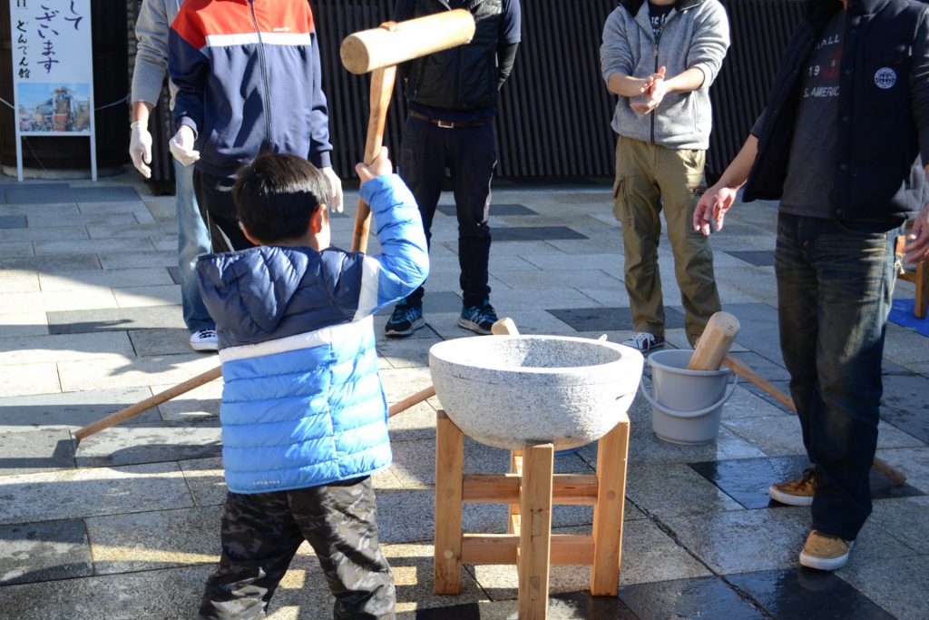 餅つきをする少年