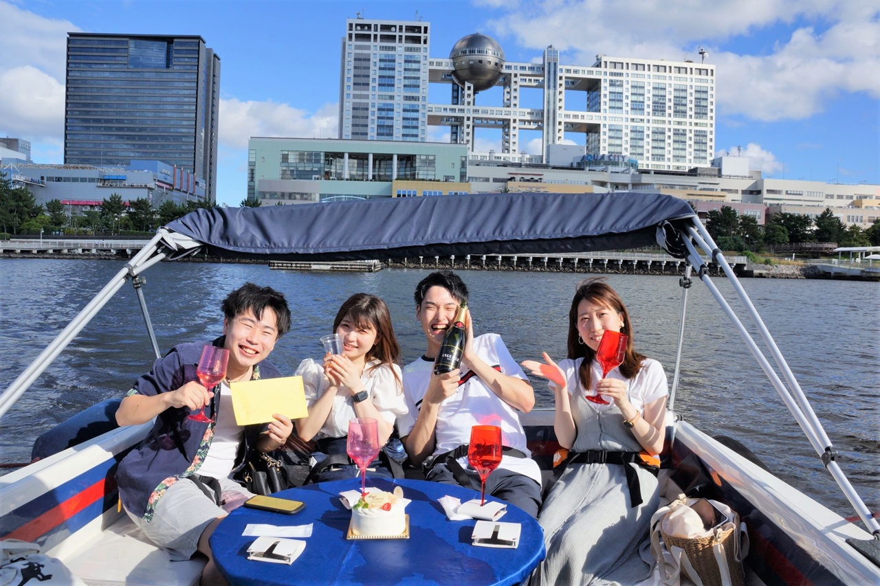 小型クルーザーで東京湾クルージングを楽しむ男女グループ