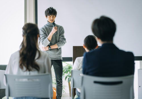 マイクを持つセミナー講師と観客