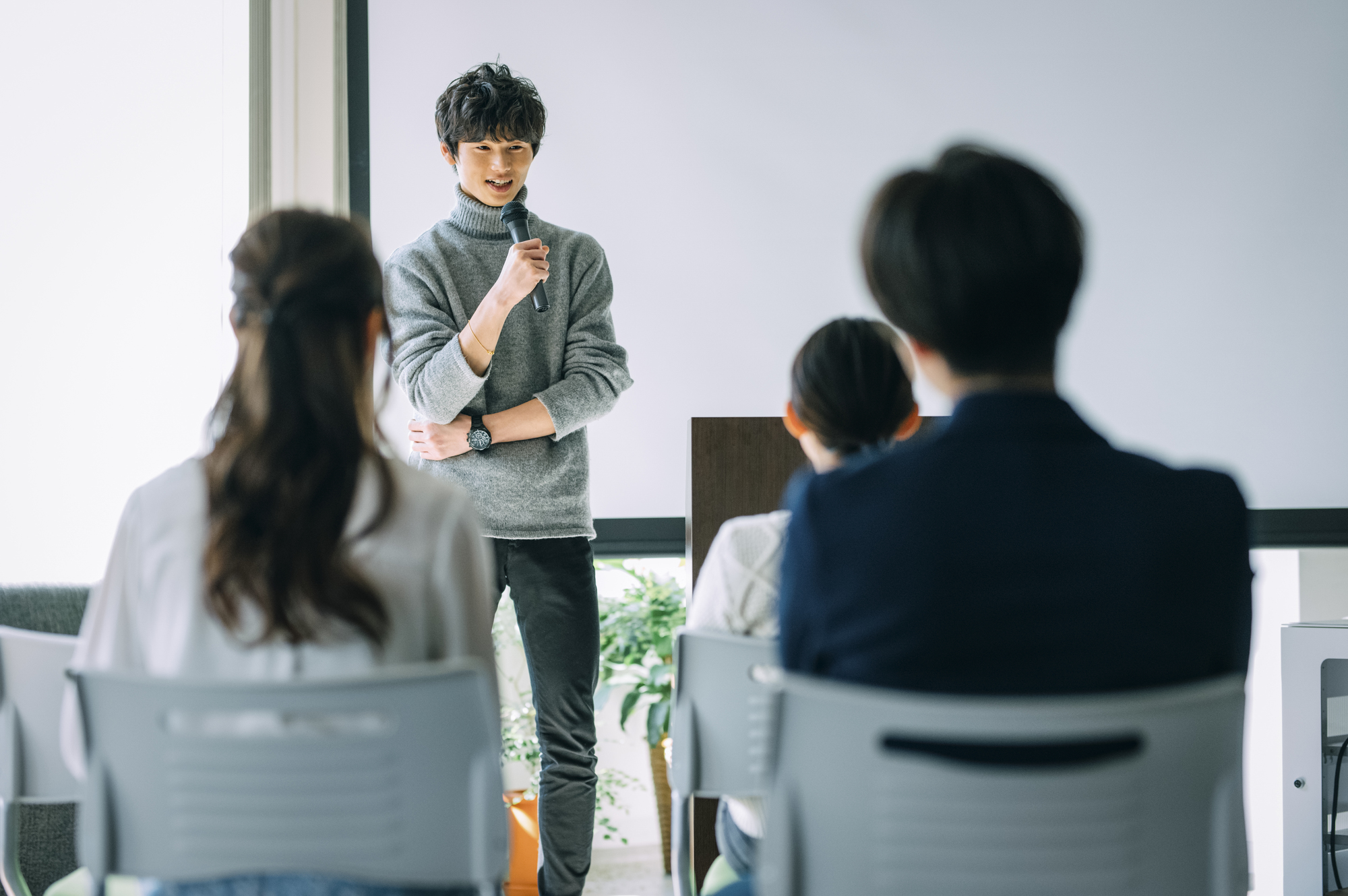 マイクを持つセミナー講師と観客